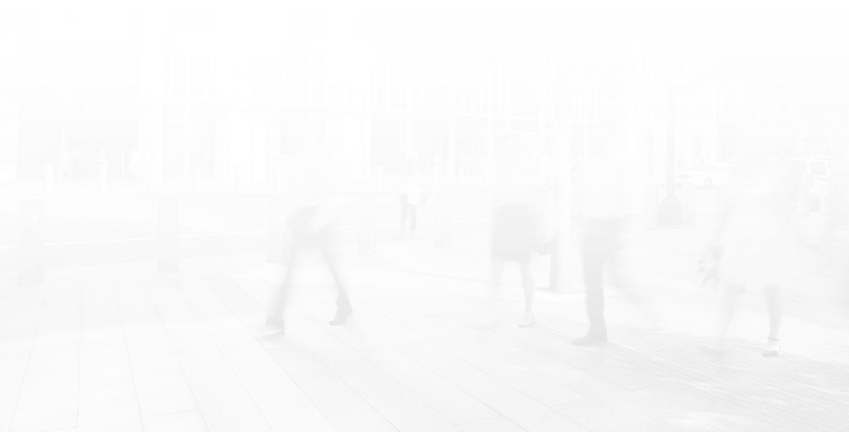 Persone in movimento su un marciapiede di fronte a un edificio moderno.